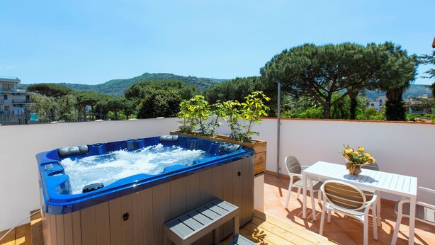 A hot tub on a wooden deck with a table and chairs, overlooking a scenic landscape. - YourHome - Jolly Pini (Sant'Agnello)