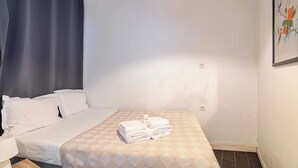 Une chambre d’hôtel avec un lit, une table de chevet, une lampe et un tableau au mur.