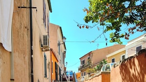 A narrow street with stone steps leading to a building with a balcony. - YourHome - La Maddalena Blue House (La Maddalena)