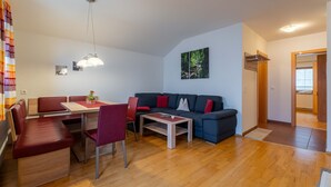 Una sala de estar con sofá, mesa de comedor, sillas y una mesa de centro.