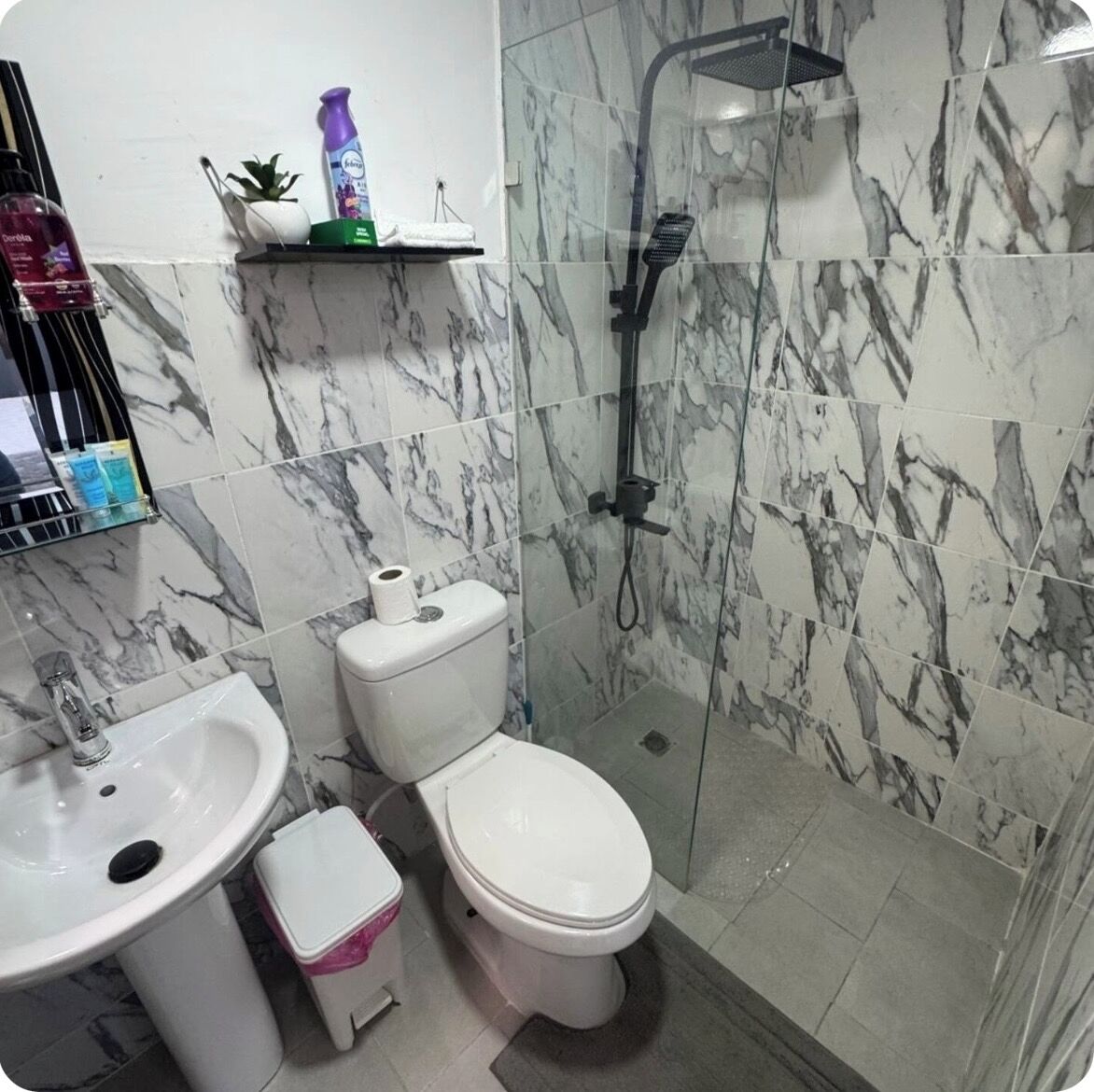 Un baño con lavamanos, inodoro y ducha.