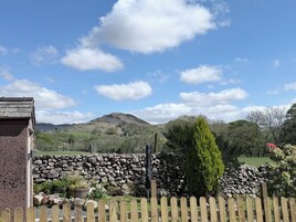 A stone wall, a wooden fence, and a mountain in the background.