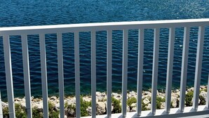 A waterfront view with a clear sky, a fountain, and a wooden deck. - Central located cozy cabin with resort amenities (Naples)
