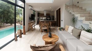 Ein modernes Interieur mit Essbereich, Küche und Blick auf einen Pool.