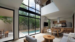 Ein modernes Interieur mit Blick auf einen Pool, einer Essecke und einer Küche.