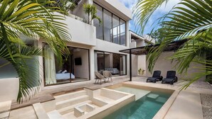 Et moderne hus med swimmingpool, udendørs møbler og et stort vindue med udsigt over poolen.