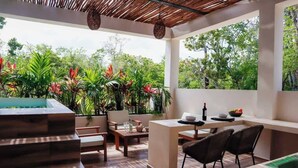 Um pátio moderno ao ar livre com piscina, área de estar e vegetação exuberante.
