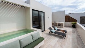 A modern outdoor patio with a pool, lounge chairs, and a dining area. - Luxury Penthouse Private Rooftop Pool Concierge (Tulum)