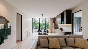 A modern living room with a sofa, a dining area, and a kitchen. - Luxury Penthouse Private Rooftop Pool Concierge (Tulum)