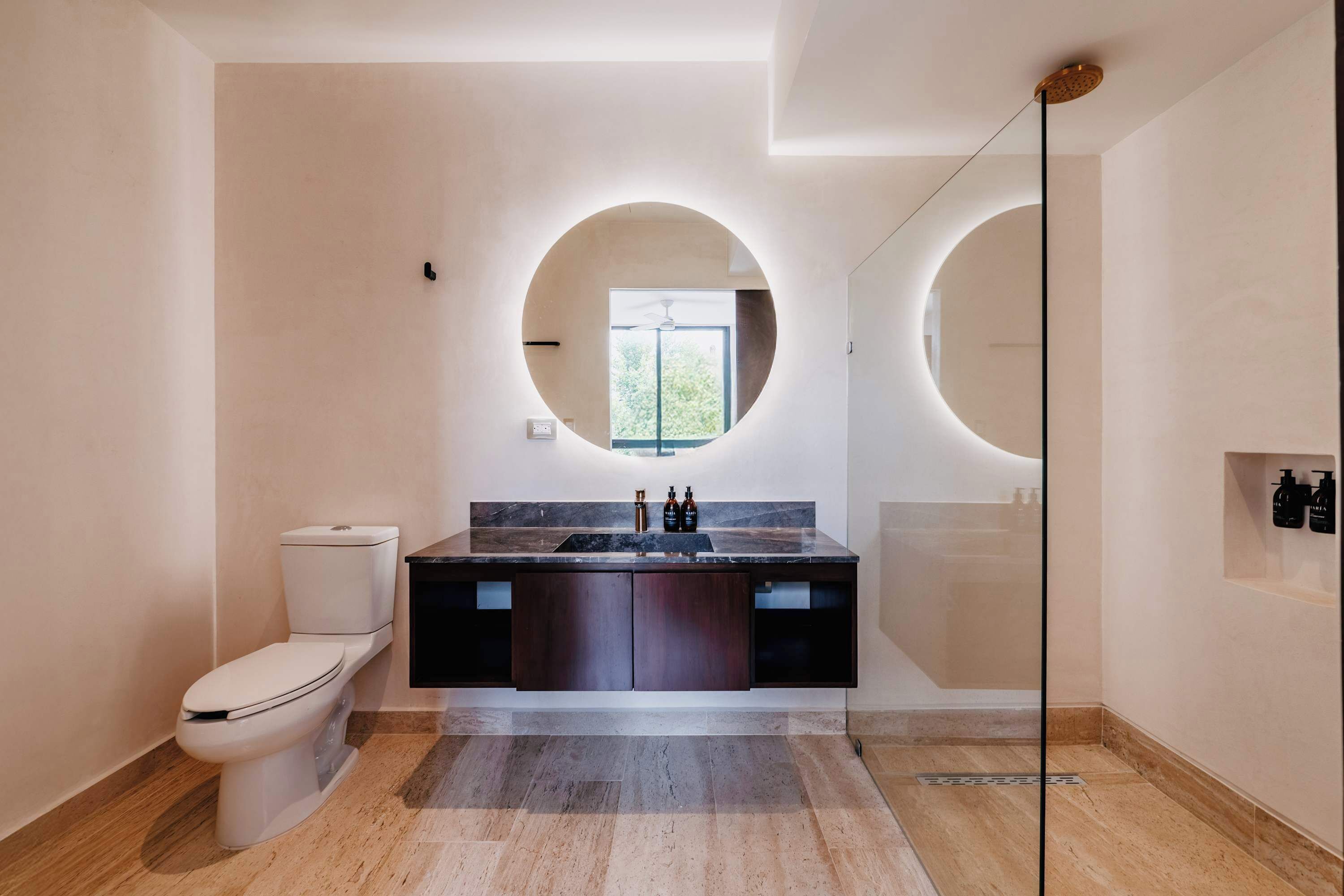 A modern bathroom with a toilet, sink, and shower.