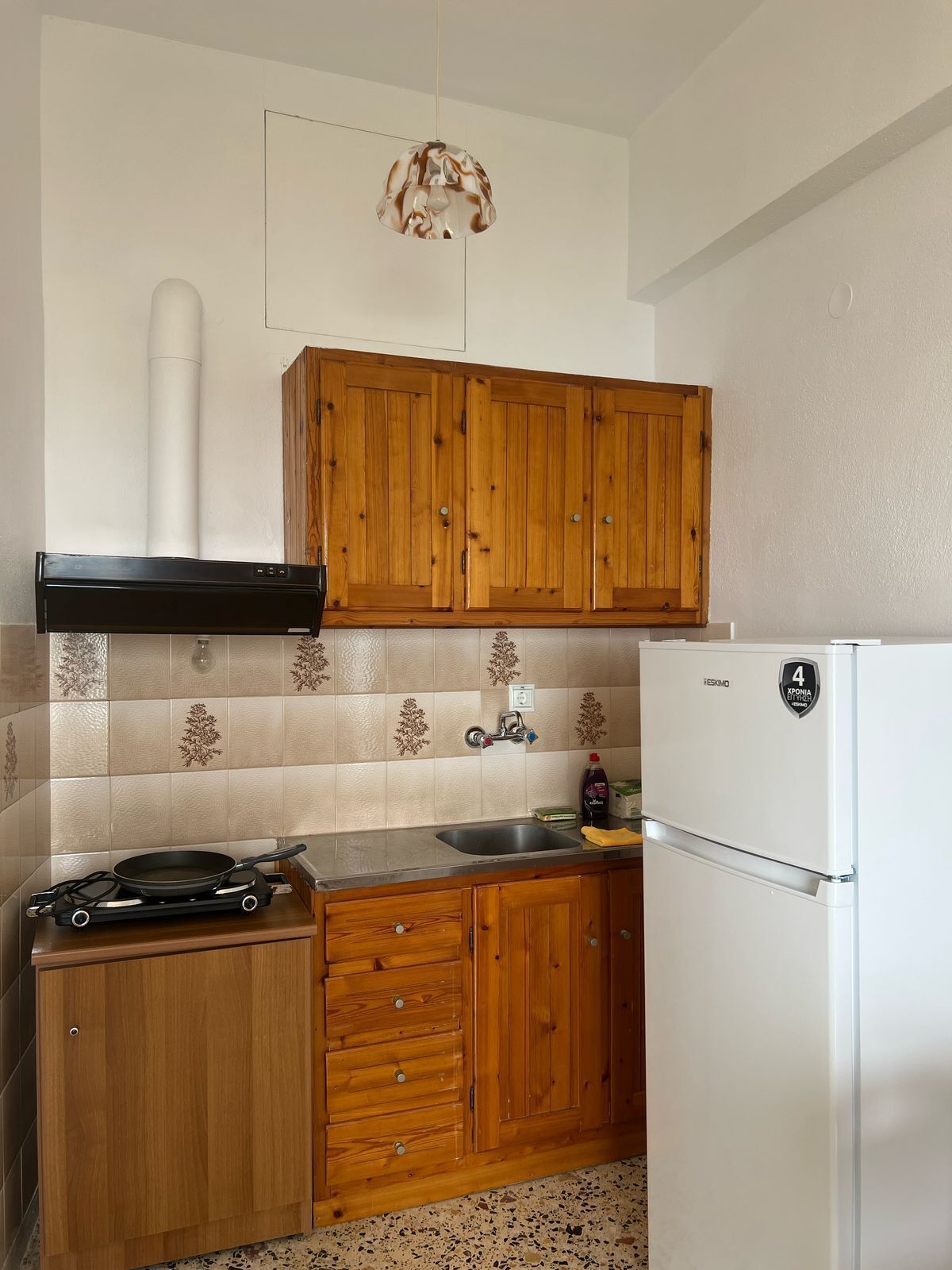 Eine Küche mit Holzausstattung, einem Herd, einer Spüle und einem Kühlschrank.
