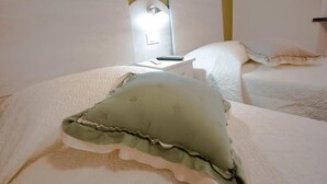 Une chambre d’hôtel avec un lit, une table de chevet avec une lampe et une petite table d’appoint.