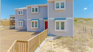 A beachfront property with a wooden deck, a red door, and a clear view of the ocean. - JL #BR-9 - The Breakers 9 - Oceanfront - Community Pool (Kill Devil Hills)