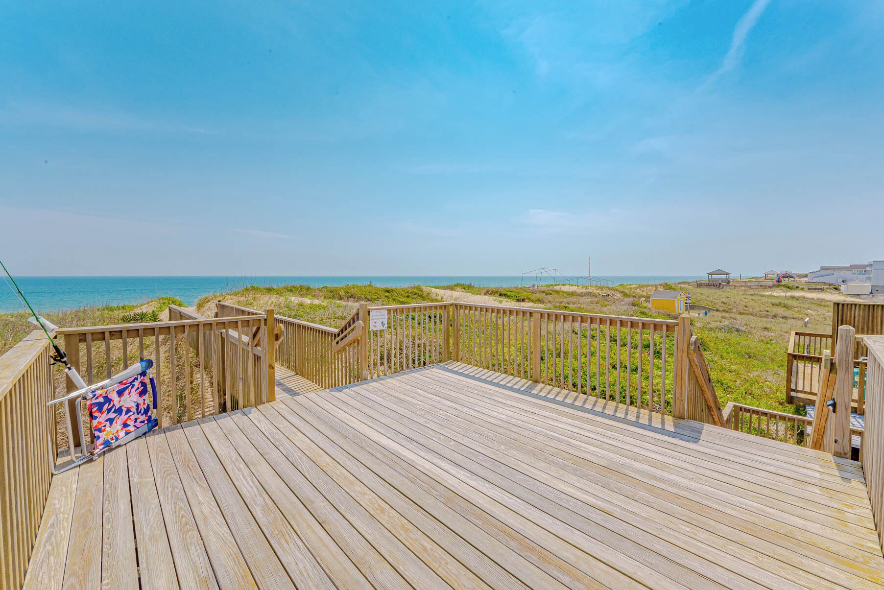 Una passerella in legno che conduce a una spiaggia con vista libera sull'oceano.