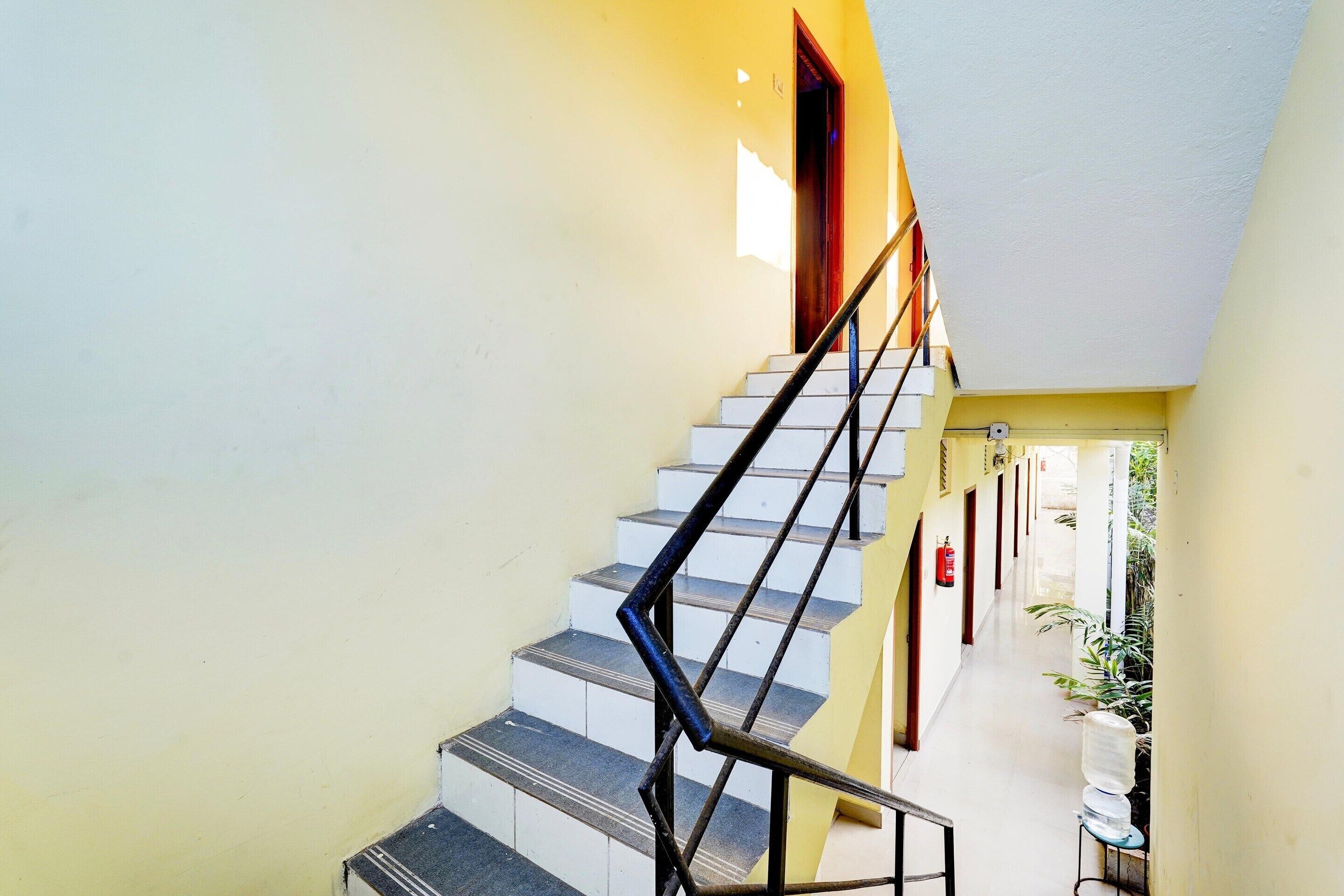 A staircase with a metal handrail leading to a landing.