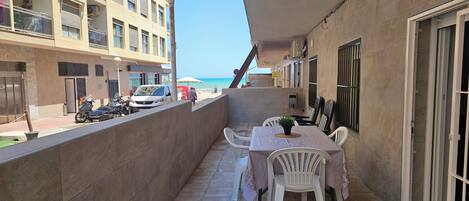 Appartement, meerdere bedden, balkon, uitzicht op strand | Buiten dineren