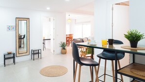 A modern kitchen with a refrigerator, a dining table with chairs, and a large mirror. - Apartamento Sirena (Guardamar del Segura)