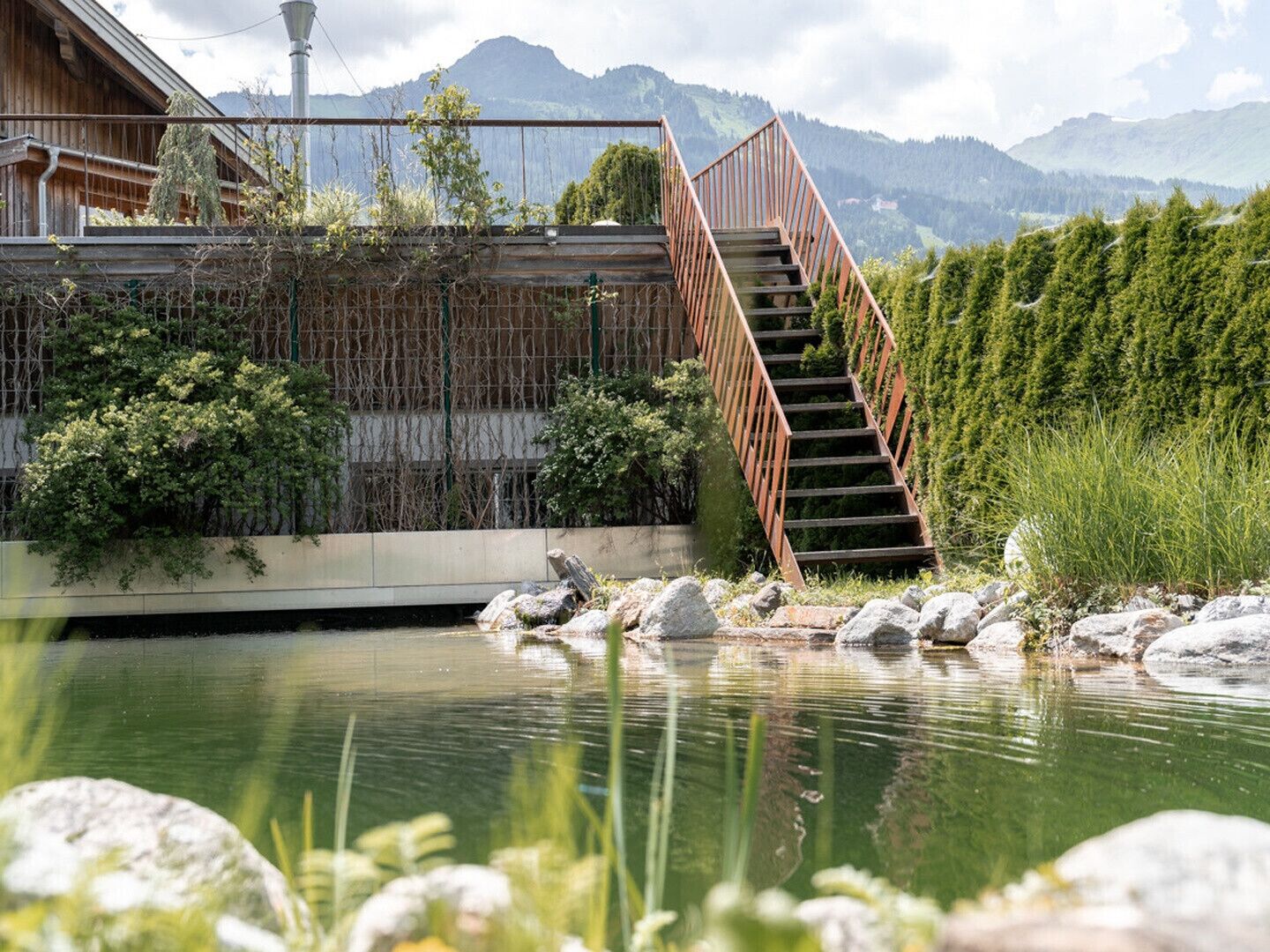 A wooden staircase leading to a building with a view of mountains.