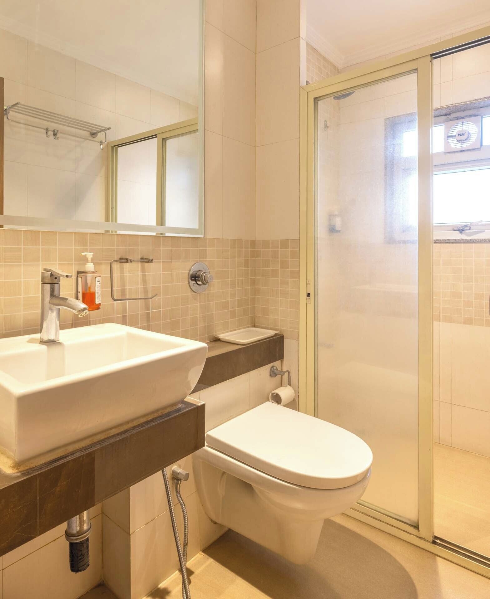 A bathroom with a sink, toilet, and glass shower enclosure.