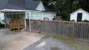 Ein Wohnhaus mit Holzzaun, einer Veranda mit Bank und einer Garage.