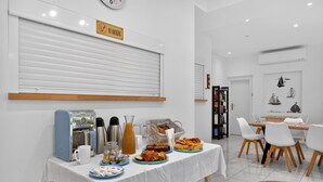 Un buffet de petit-déjeuner proposant divers aliments, une machine à café et un panneau « Il est interdit de fumer » sur le mur.