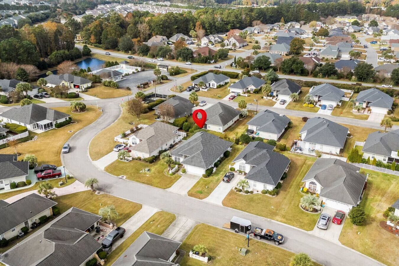 Oversigtsbillede af et boligområde med huse, gader og et stort vandområde.