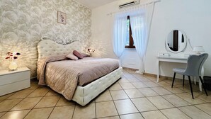 A bedroom with a bed, bedside table, lamp, mirror, and a window with curtains. - YourHome - Letizia's House (Sorrento)