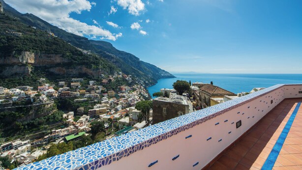 A coastal town with terraced buildings, a clear blue sea, and a tiled walkway. - YourHome - Lorena Maria House Positano (Positano)