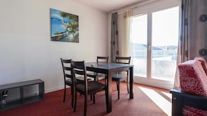 A room with a dining table, chairs, a painting, a sliding glass door, and a sofa. - Bright Hillside Escape With Pool, Grasse (Grasse)