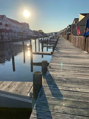 A wooden pier extending into calm water, with a clear sky and the sun low on the horizon. - Walk to Beach, Indoor/Outdoor Pools, Steps to Grocery (Ocean City)