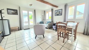 Un vaste espace de vie comprenant une table à manger, des chaises, un canapé et un téléviseur.