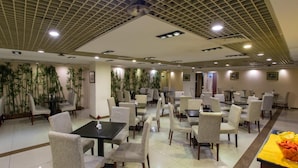 A spacious dining area with multiple tables and chairs, a ceiling with a grid pattern, and bamboo plants along the walls. - Jinjiang Inn Beijing Yizhuang Economic & Technical (Beijing)