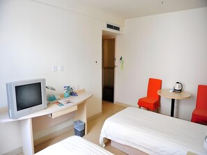 A hotel room with a TV, a desk, two beds, a small table, and two red chairs. - Jinjiang Inn Beijing Yizhuang Economic & Technical (Beijing)