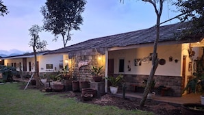 A row of houses with stone walls and tiled roofs, surrounded by potted plants and trees. - Dagope Homestay (Lembang)