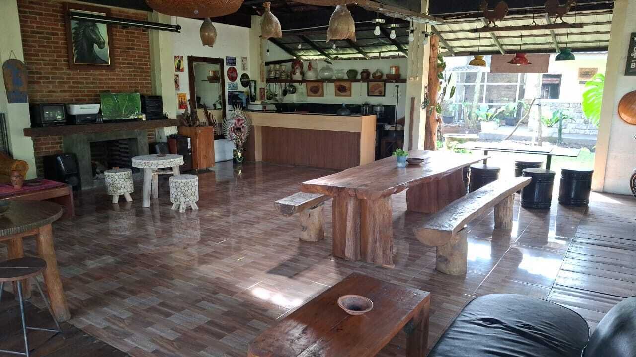 A rustic interior with a wooden floor, a bar area, and a seating arrangement.