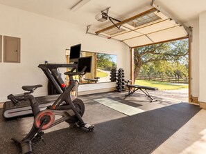 A home gym with exercise equipment, a treadmill, and a stationary bike. - Luxury Ranch: 10 Acres, Pool, Pickleball, Sauna, Party Barn (Dripping Springs)