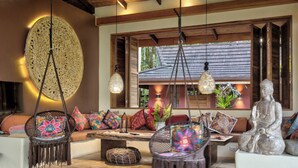Ein gemütliches Interieur mit einem großen Wandkunstwerk, hängenden Lampen und einer Buddha-Statue.