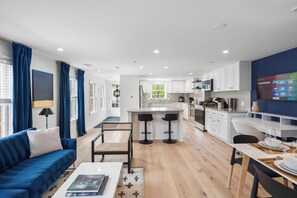 Eine moderne Wohnung mit Wohnzimmer, Küche und Essbereich.