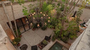 A courtyard with a fountain, seating area, and a decorative chandelier. - Casa Ek: House•Safe•Fast WiFi•Pool•Walkable  area (Mérida)