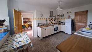 A kitchen with a wooden table, a stove, a microwave, and a sink. - Former wine estate with breathtaking panoramic views! (Canelli)