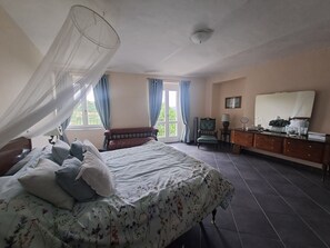 A bedroom with a bed, a chair, a dresser, and a window with curtains. - Former wine estate with breathtaking panoramic views! (Canelli)