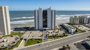 Un hotel de gran altura con un patio central, junto a la playa y vistas al océano.