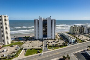 Ein Hochhaus-Hotel mit Innenhof, neben einem Strand und mit Blick aufs Meer.