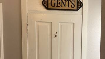 A white door with two signs above it reading 'Ladies' and 'Gents.'