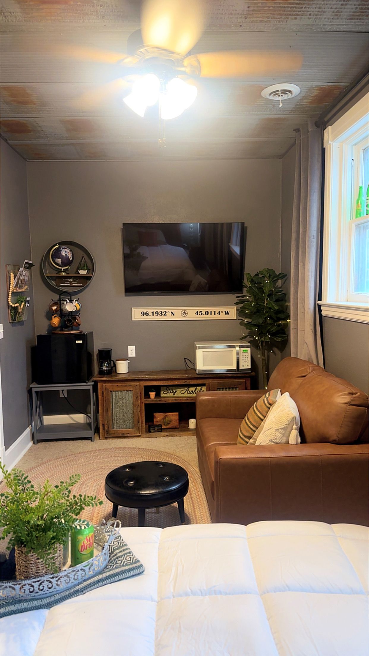 A living room with a television, a sofa, a coffee table, and a decorative globe.