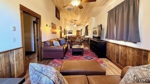 A cozy living room with a sofa, ottoman, and a ceiling fan. - Elk Suite: Epic Paradise Valley Views will amaze. (Emigrant)