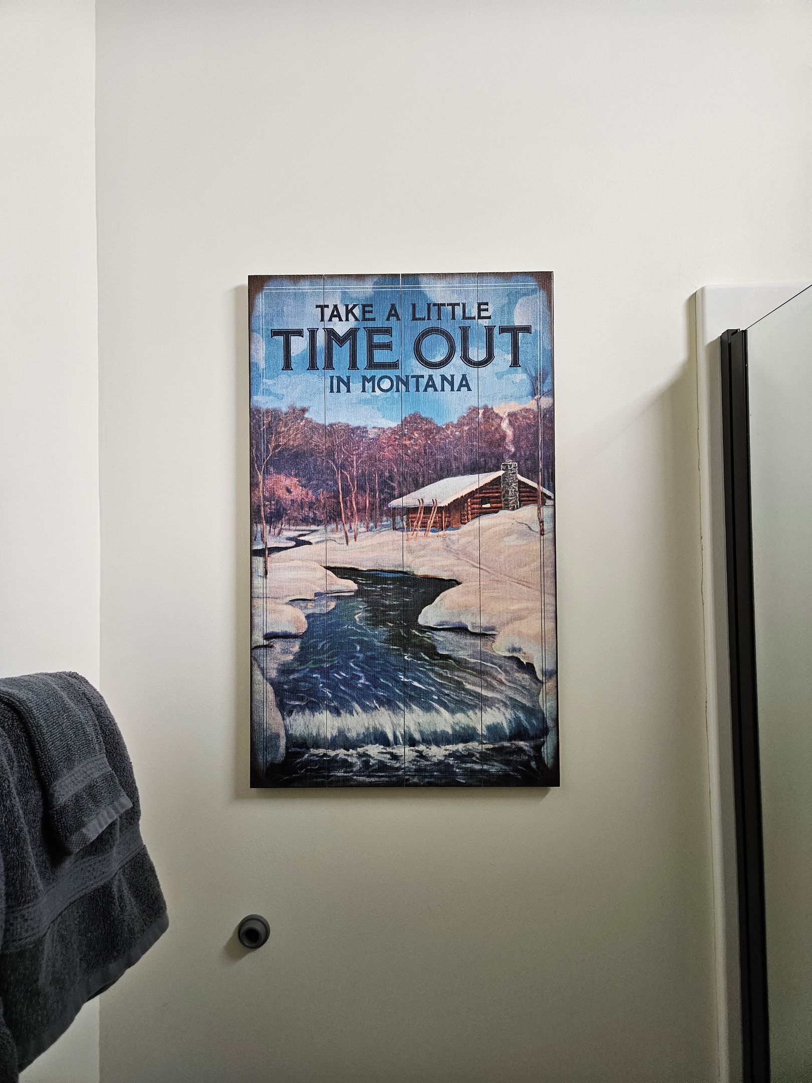 A framed poster on a wall with the text 'TAKE A LITTLE TIME OUT IN MONTANA'.