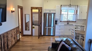 A modern kitchen with a refrigerator, stove, and dining area. - Rainbow Trout Suite in Emigrant (Emigrant)