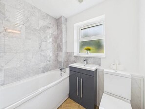Kylpyhuone, jossa on kylpyamme, pesuallas ja wc.