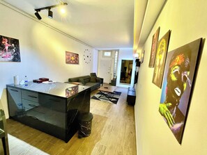 A modern kitchen with a central island, a dining area with a sofa, and a hallway with artwork. - Cosy Flat Neartaksim and Nişantaşi (Istanbul)